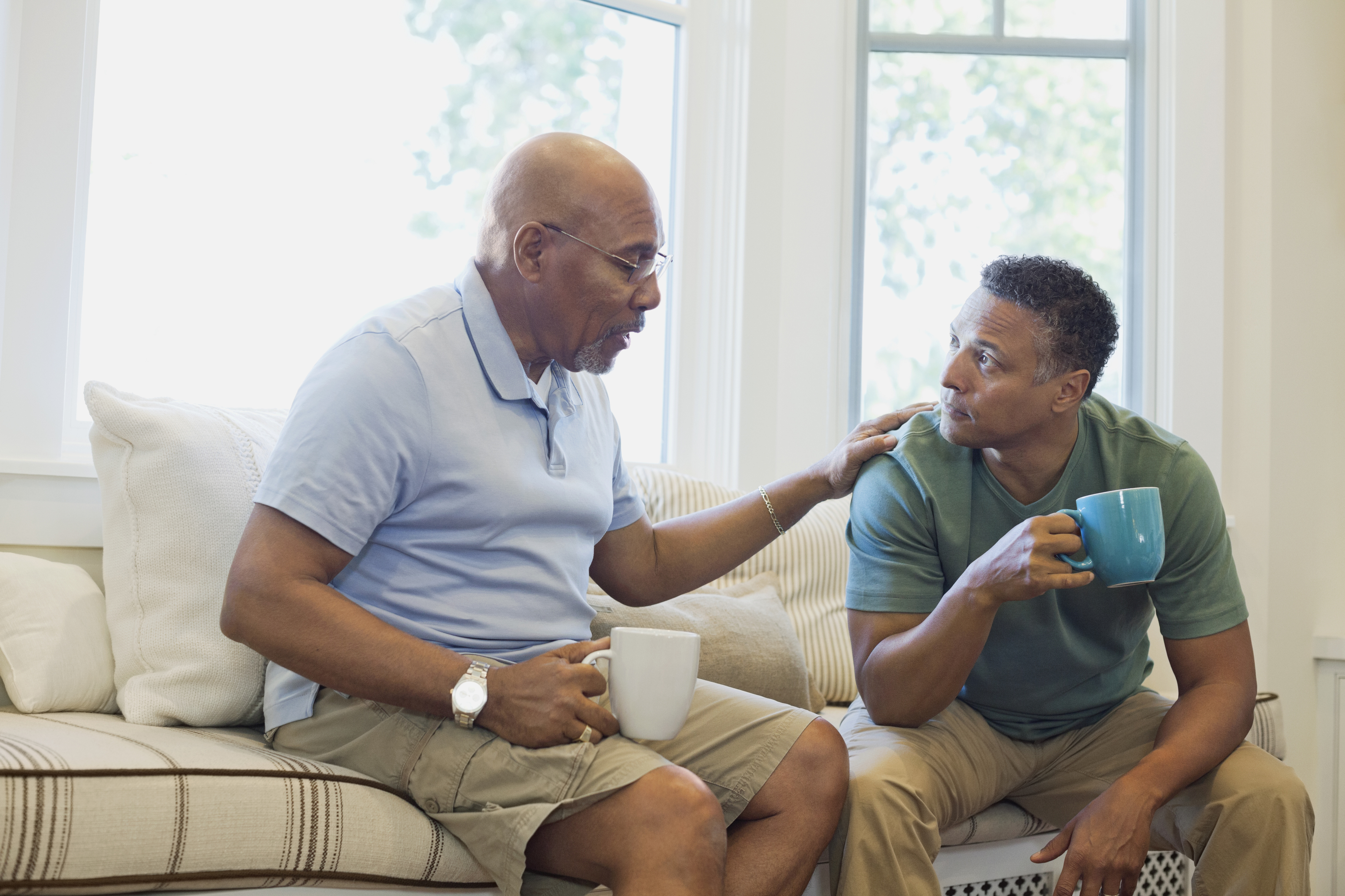 Two men talking over a mug of coffee