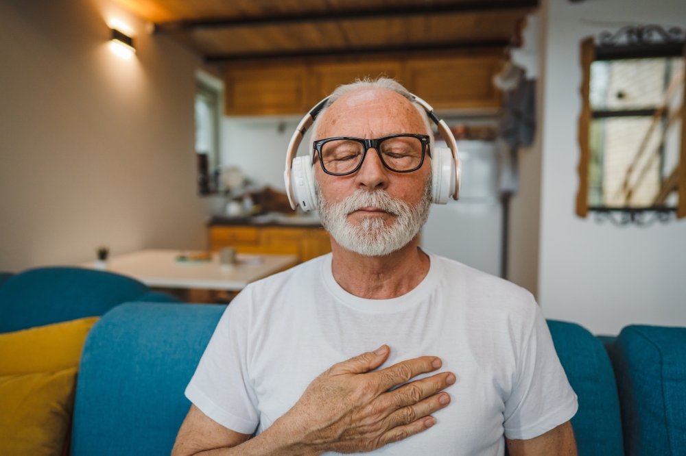 Mature man meditating with headphones on