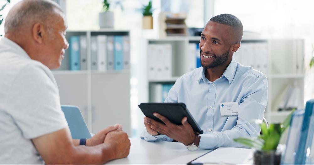 Black male doctor speaking with White male patient